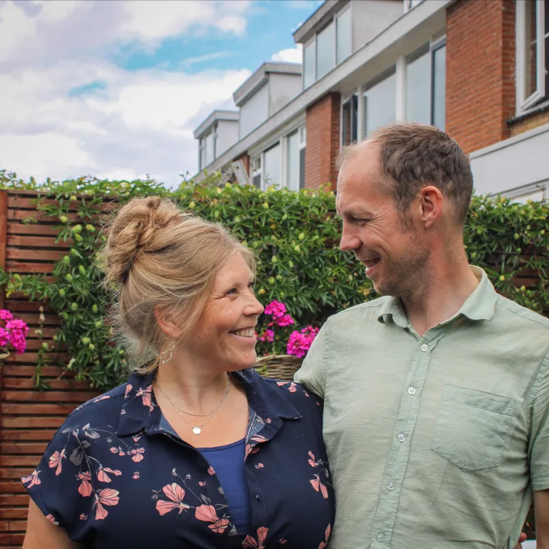 Een man en een vrouw kijken elkaar lachend aan