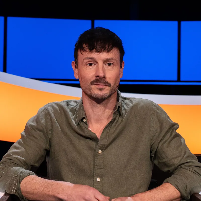 Man met donker haar en snor en groen overhemd