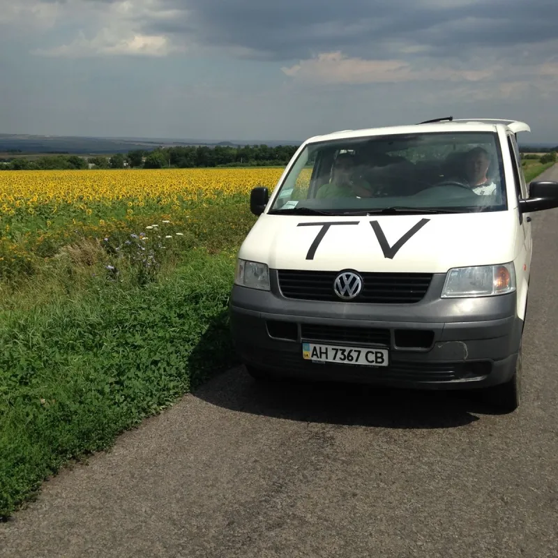 Joris en zijn bus bij een veld met zonnebloemen in Oekraïne