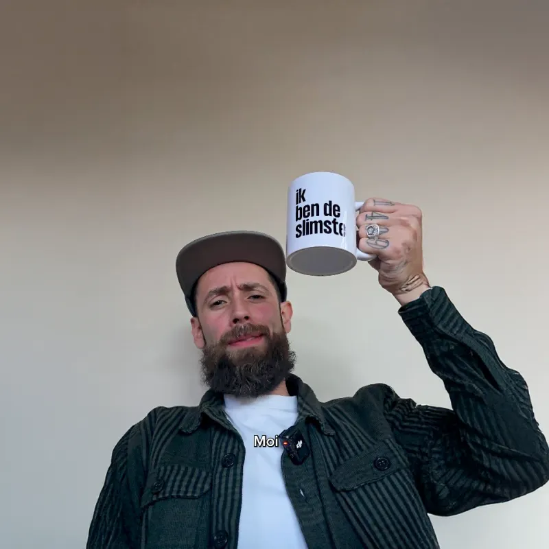 een man houdt een mok in de lucht