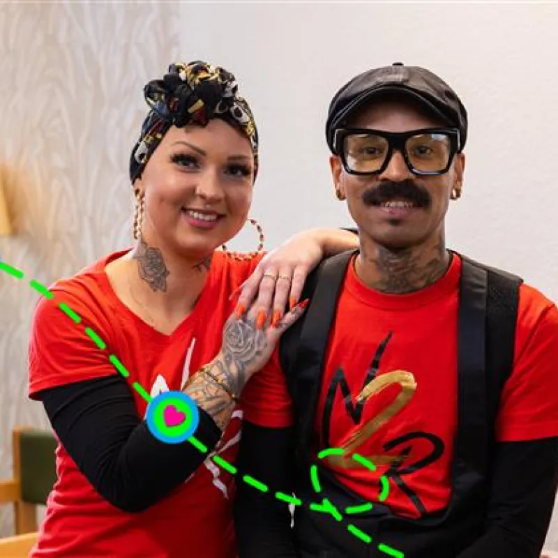 Man en vrouw staan naast elkaar. Man met snor en bril en vrouw met grote oorbellen.