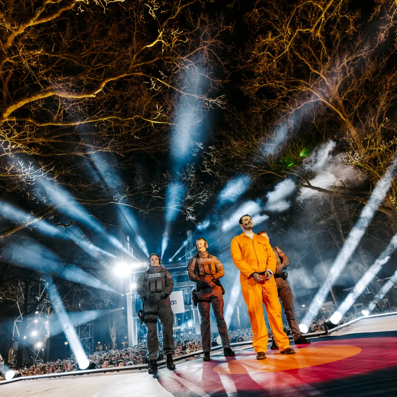 Man in oranje pak met politieagenten