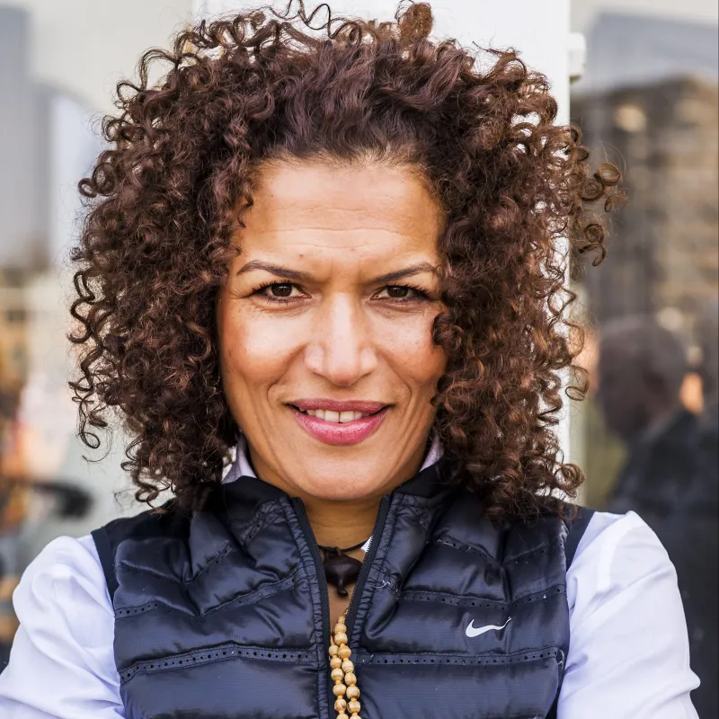 Lachende mevrouw met bruine krullen