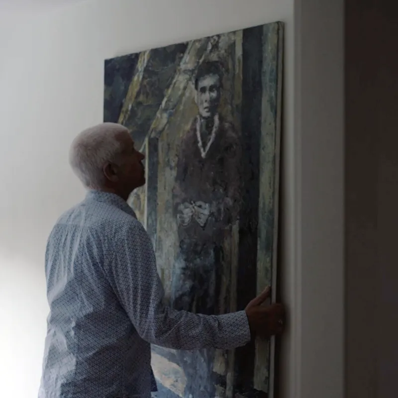 Man hangt schilderij op