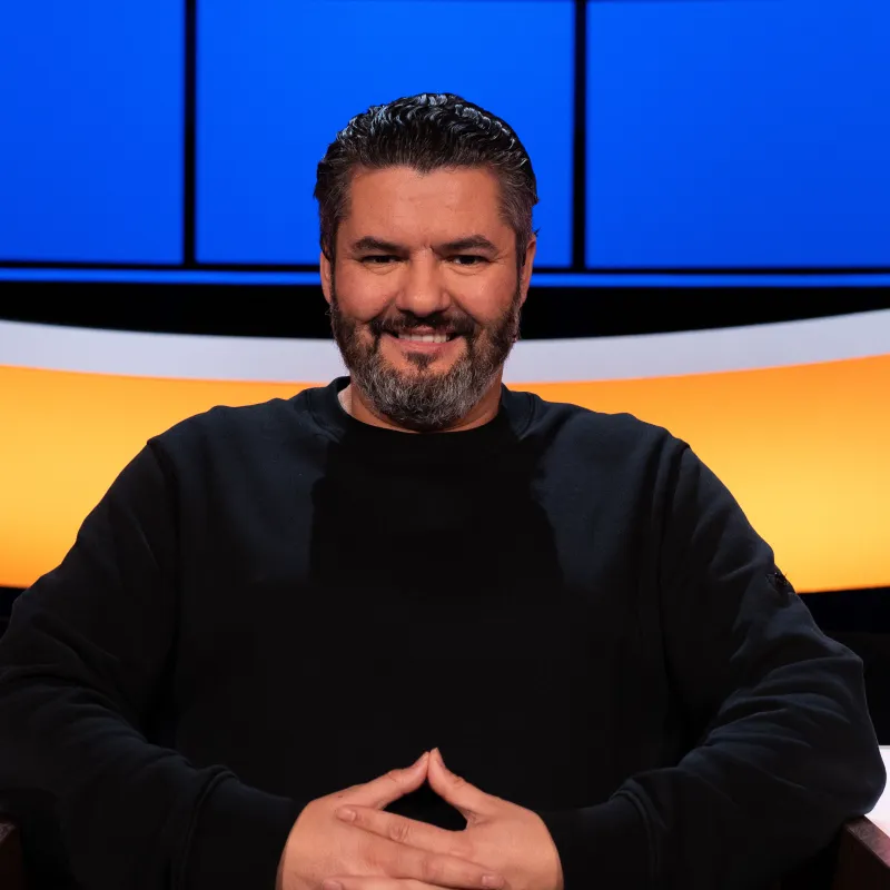 Lachende man met zwart haar en een zwarte baard 