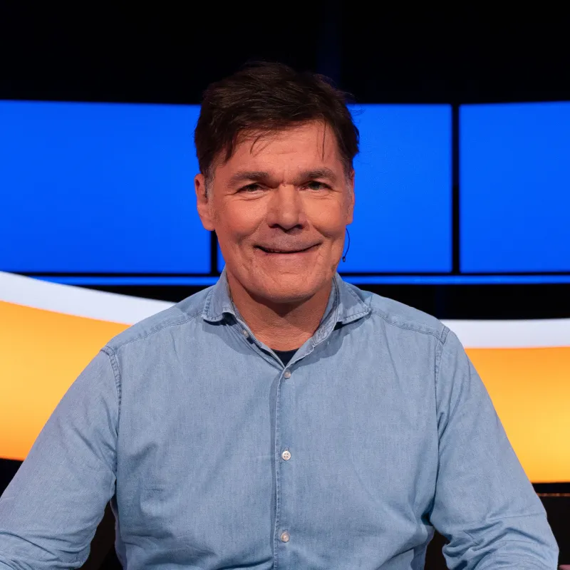 Man met bruin haar en blauw overhemd