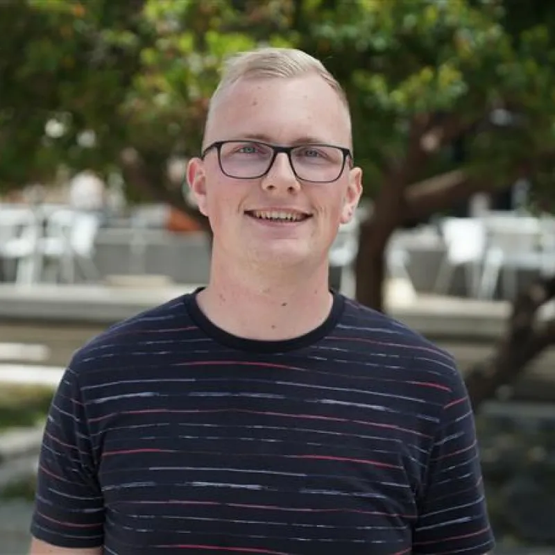 Man met bril lachend in camera met zwart shirt