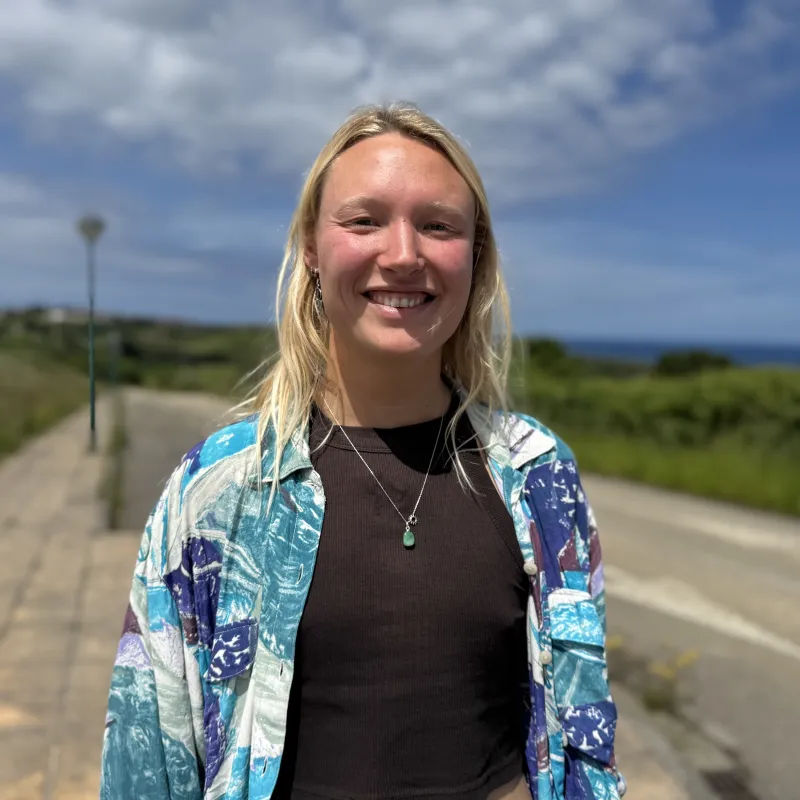 Vrouw in blauw jasje lachend naar camera