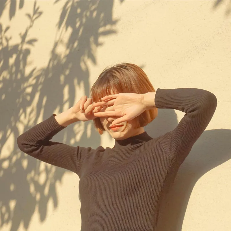 Vrouw met hand voor haar ogen tegen de zon