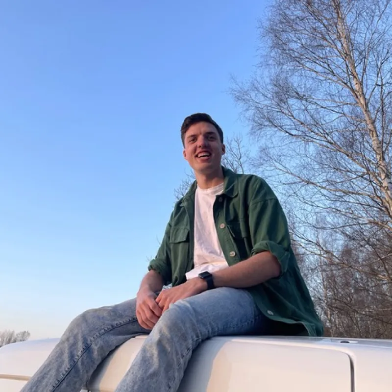 Lachende man zit bovenop een camper