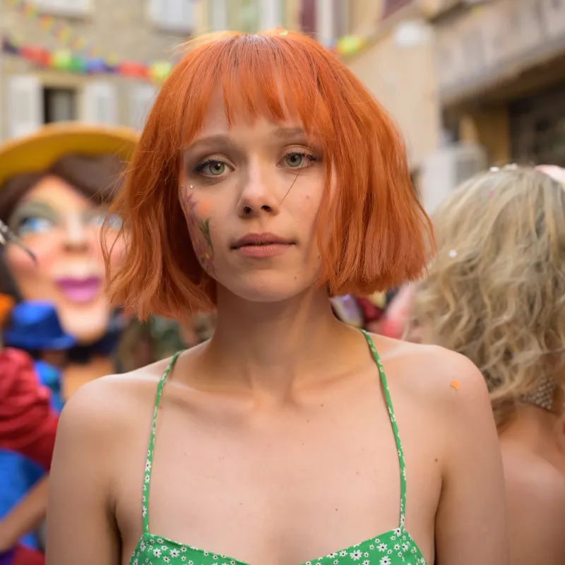 Vrouw met fel orange haar staart voor zich uit