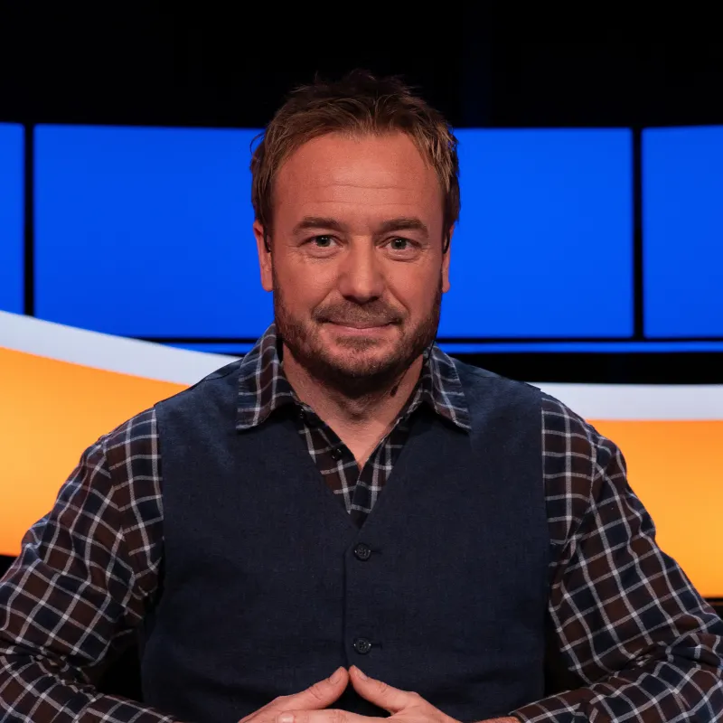 Man met geruite blouse en blauw gilet 