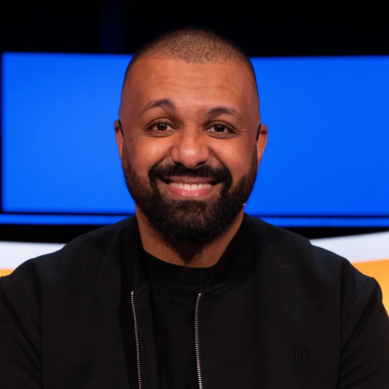 Lachende man met zwarte baard en zwart vest