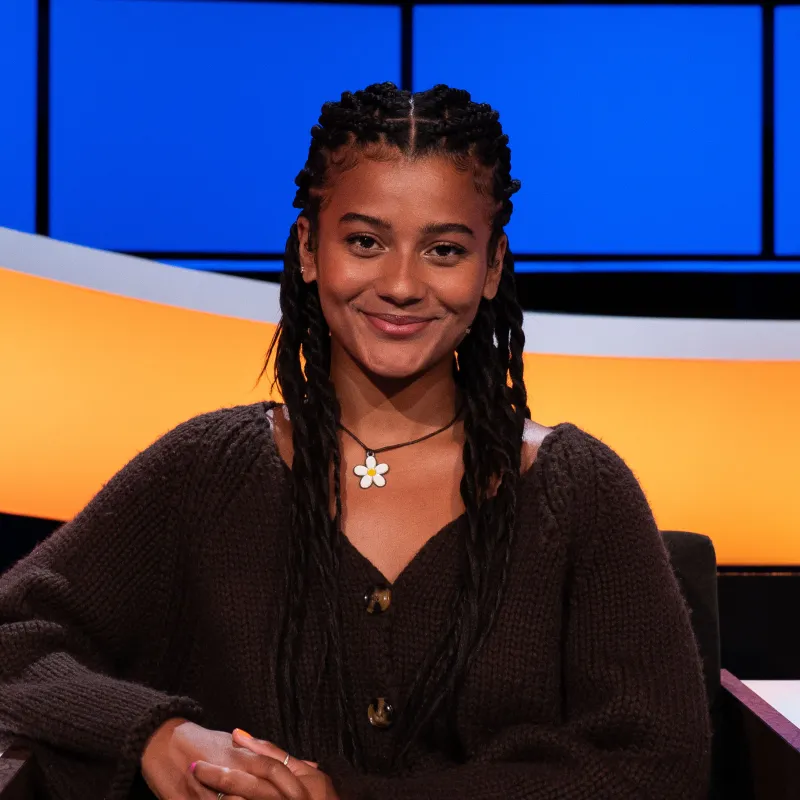 Jonge lachende vrouw met zwart haar en bloemenketting