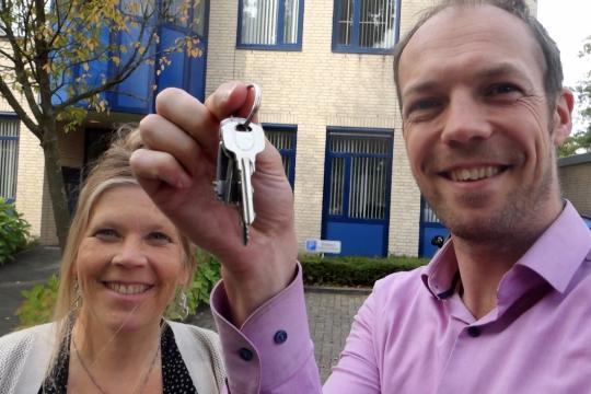 Man en vrouw blij met sleutel omhoog