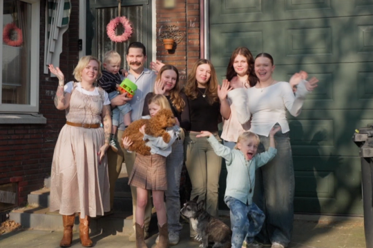 De familie Bal poseert voor hun huis