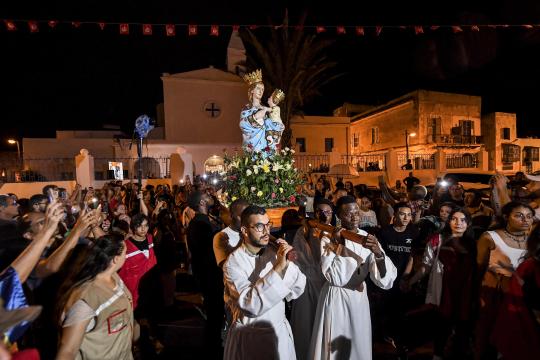Worshippers carry the shrine of the Madonna of Trapani during the procession in the annual Christian Roman Catholic feast day of the Assumption of the Virgin Mary at the Saint-Augustin and Saint-Fidèle church in La Goulette suburb of Tunisia's capital Tunis on August 15, 2022. The Madonna of Trapani procession, marking the Catholic Feast of the Assumption, is an echo of a "forgotten history" researchers of Italian origin say offers a model for coexistence with migrants, among faiths and ethnicities. 