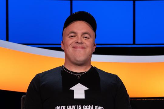 Lachende man met pet en de tekst 'deze guy is echt slim' op z'n t-shirt