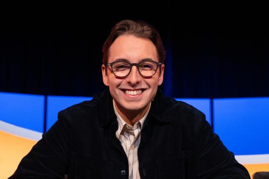 Jongen met bril en zwart vest in de studio