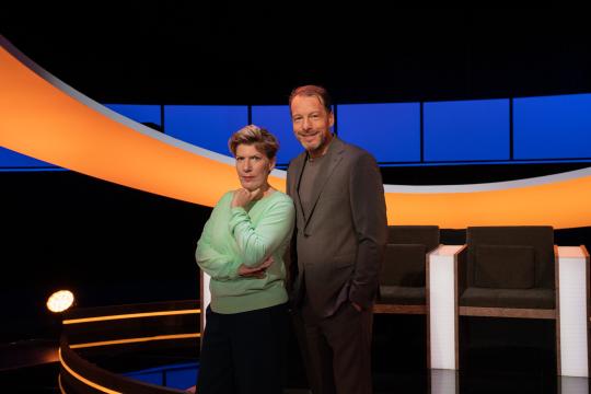 Man en vrouw lachend in een studio