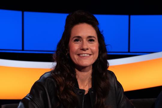 Lachende vrouw met zwart haar en zwarte jack