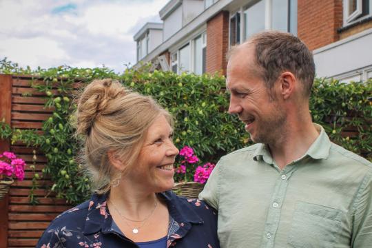 Een man en een vrouw kijken elkaar lachend aan