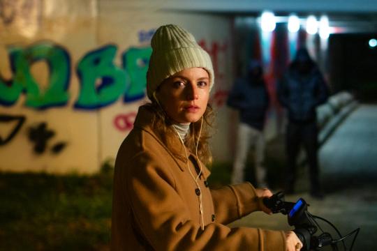 een vrouw op een fiets bij een tunnel