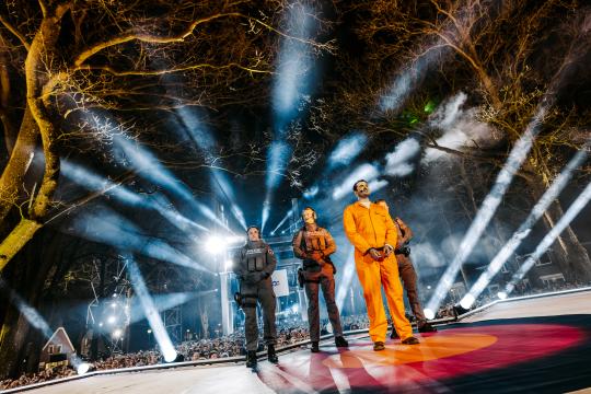 Man in oranje pak met politieagenten