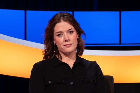 Vrouw met halflang haar en zwarte blouse