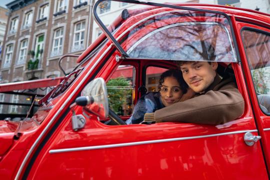twee mensen in een rode auto