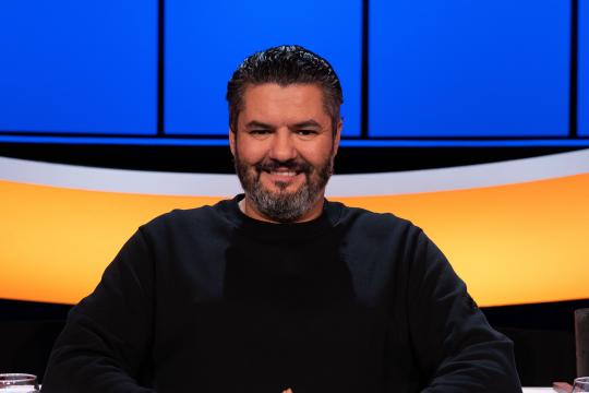 Lachende man met zwart haar en een zwarte baard 