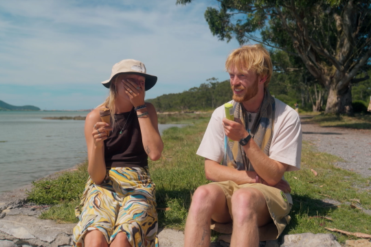 Man en vrouw op grasveld lachend met eten