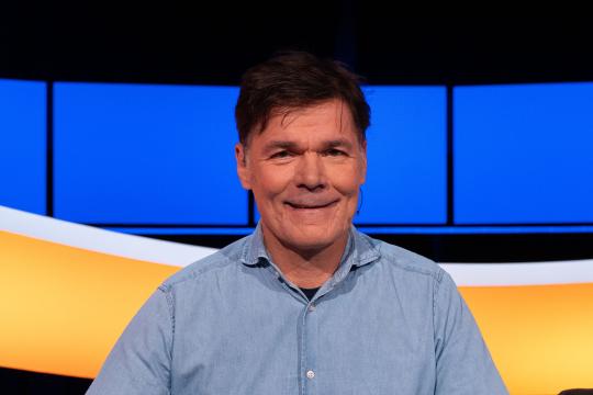 Man met bruin haar en blauw overhemd