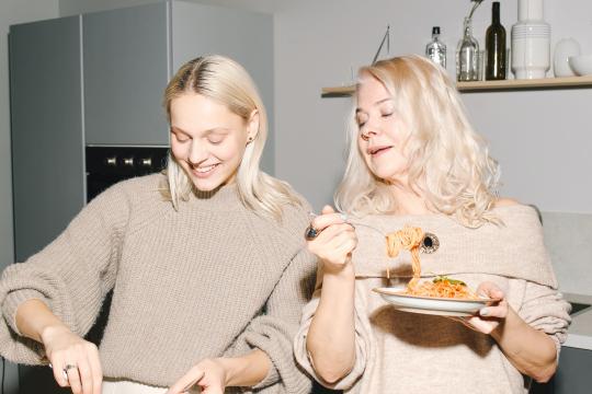 twee vrouwen aan het eten in de keuken