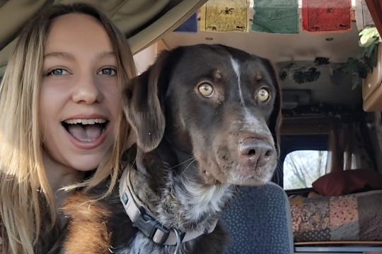 Onderweg naar liefde - Fieke Vrouw met hond kijkt lachend de camera in