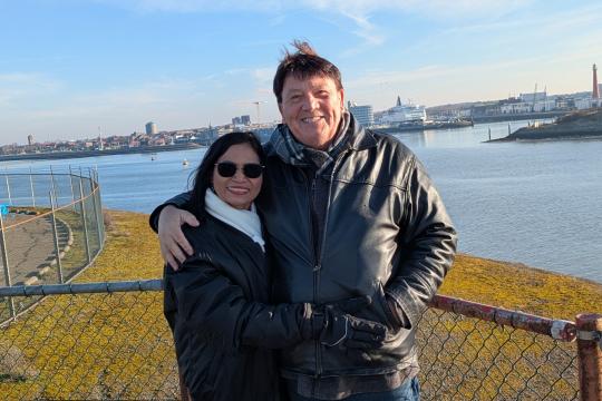 Ruud en Maleewan - Hello Goodbye Man en vrouw staan lachend voor water
