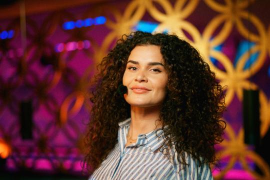 Vrouw met zwarte krullen en blouse