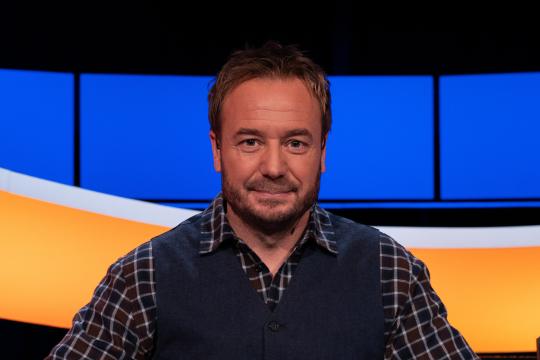 Man met geruite blouse en blauw gilet 