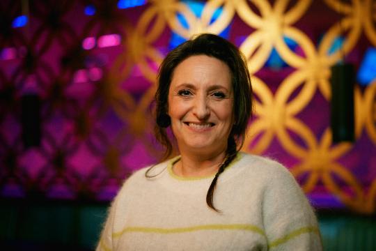 Lachende vrouw met donker haar en witte trui