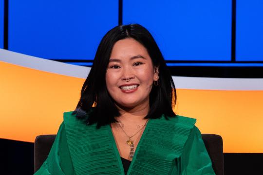 Lachende mevrouw met zwart haar en groene blouse