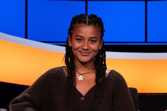 Jonge lachende vrouw met zwart haar en bloemenketting