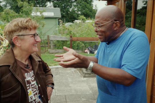 Een man en een vrouw in gesprek in een tuin