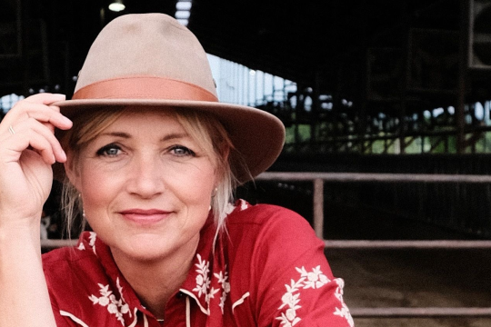 een vrouw met een hoed op in een stal