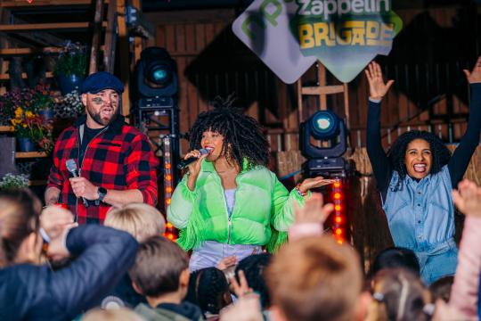 Zappelin Brigade Zingende mensen op een podium