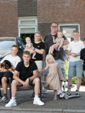 De familie De Lange uit Een huis vol poseert voor een huis