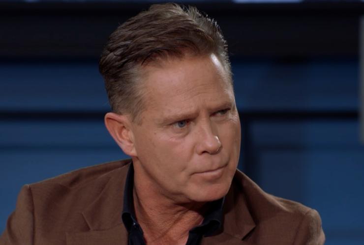 Man in bruin pak in studio kijkend naar rechts