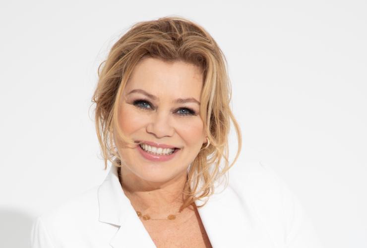 Vrouw in wit pak voor witte muur