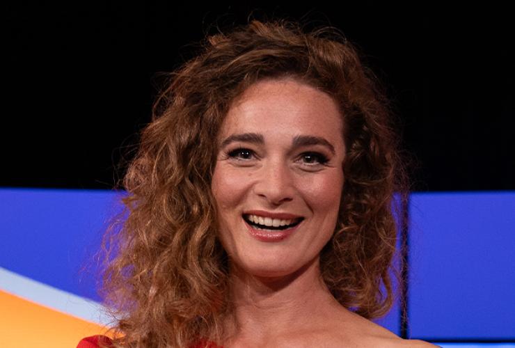 Lachende vrouw in rode jurk met schaal