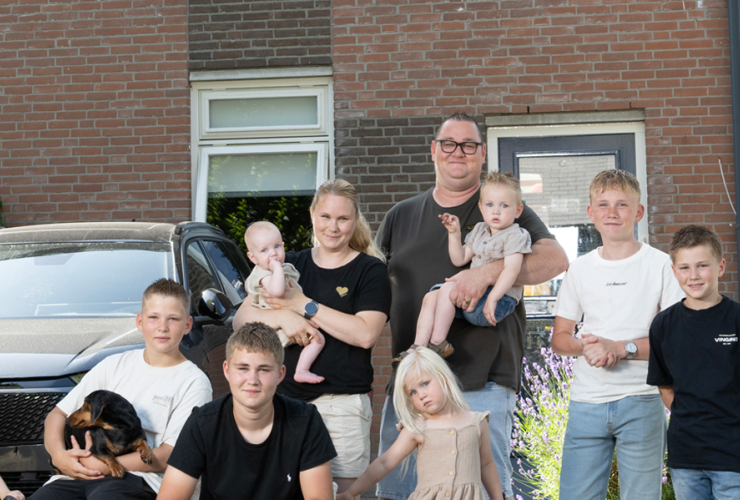 De familie De Lange uit Een huis vol poseert voor een huis