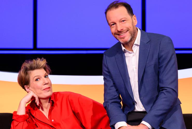 Man in blauw pak en vrouw in rood pak in studio